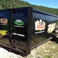 Abrollcontainer mit 38 m³ Volumen, offen und spantenfrei, Modell EKO1 in Schwarz mit Flügeltüre und auffälligem Werbeaufdruck