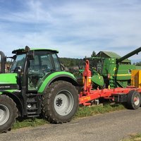 Abrollcontainer mit 36 m³ Volumen, spantenfrei, aus der Serie EKO1 in Gelb, während der Befüllung durch einen Traktor